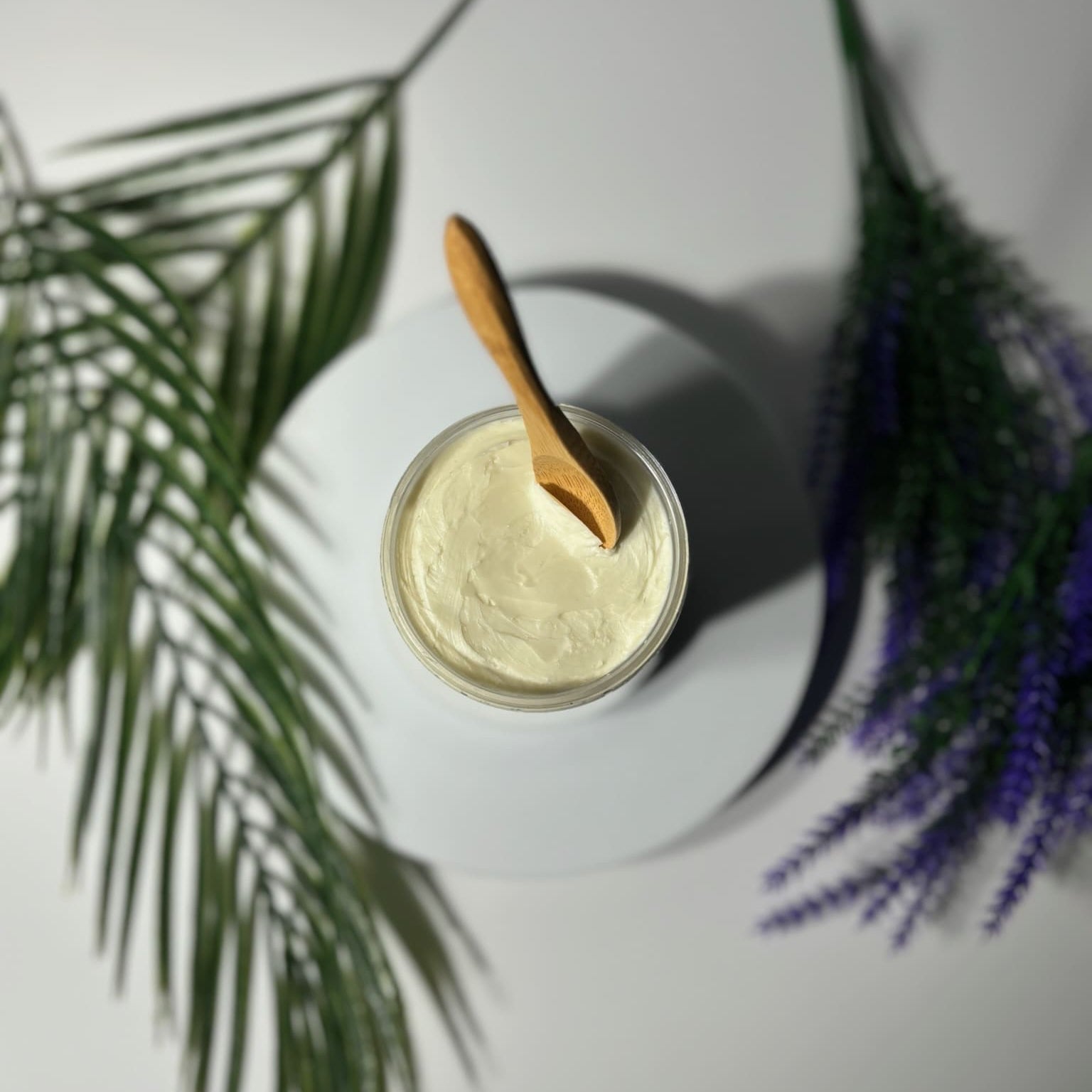 jar of lavender whipped shea body butter with a wooden spoon inside