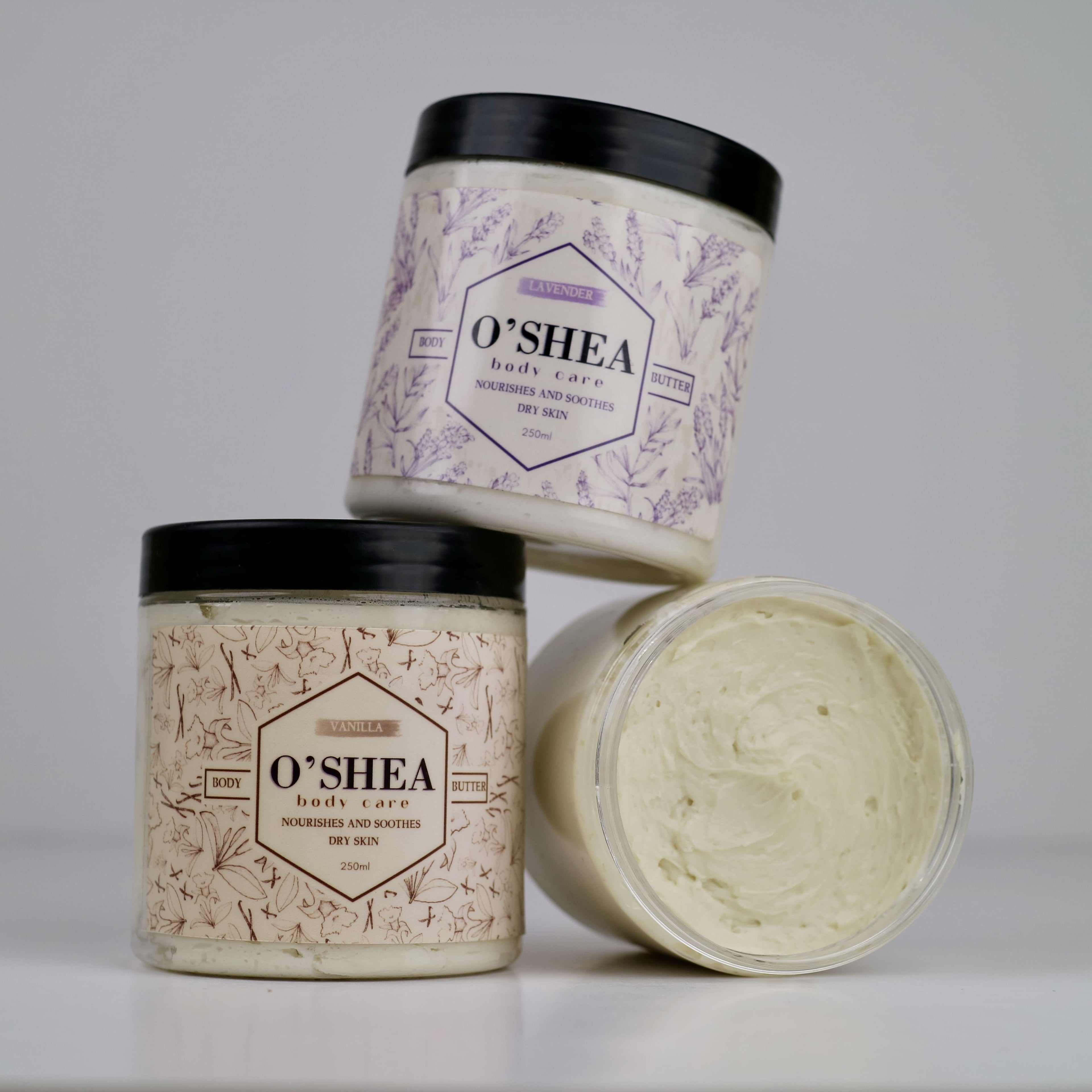 three jars of natural whipped shea body butter with one jar open