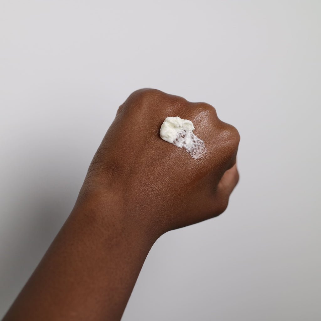 woman's hand with streak of natural shea body butter on top